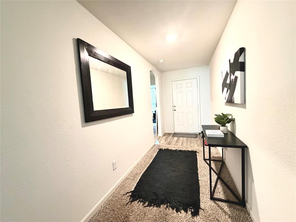 13604 Mineral Road Ponder, TX 76259 - Photo 15 of 20 Hallway with arched walkways, a textured wall, and light colored carpet