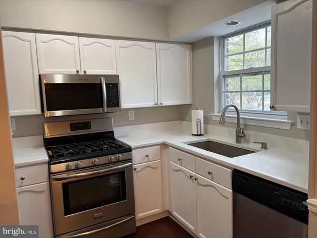 a kitchen with white cabinets and white appliances