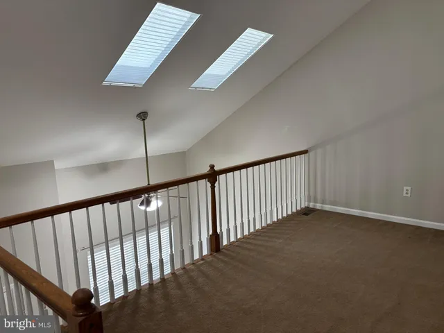 a view of staircase with railing and white walls