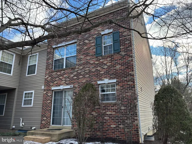 a brick building that has a tree in front of the house