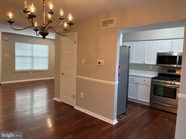a kitchen with granite countertop a sink cabinets and stainless steel appliances