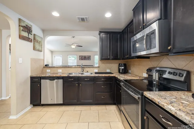 a kitchen with stainless steel appliances granite countertop a sink and stove