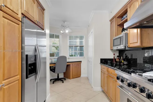 a kitchen with stainless steel appliances granite countertop a refrigerator a sink a stove and white cabinets