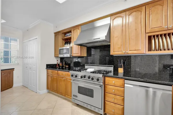a kitchen with stainless steel appliances granite countertop a stove a sink and a refrigerator