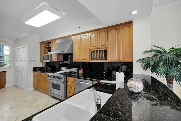 a kitchen with stainless steel appliances granite countertop a stove a sink and a microwave