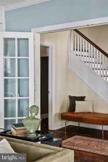 a dining room with furniture a chandelier and wooden floor