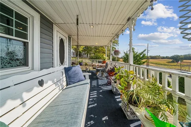 a balcony with wooden floor and outdoor seating