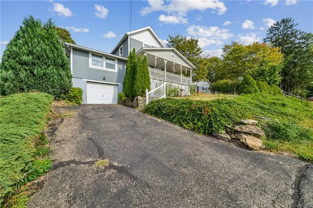 a front view of a house with a yard and potted plants
