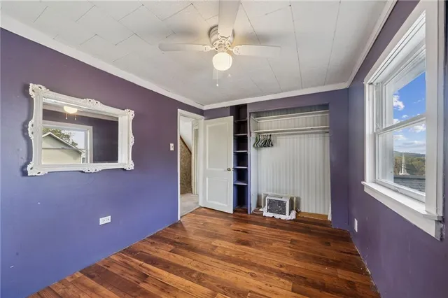 a view of a livingroom with a large window and wooden floor