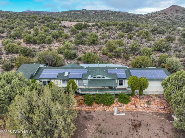 an aerial view of a house with a mountain