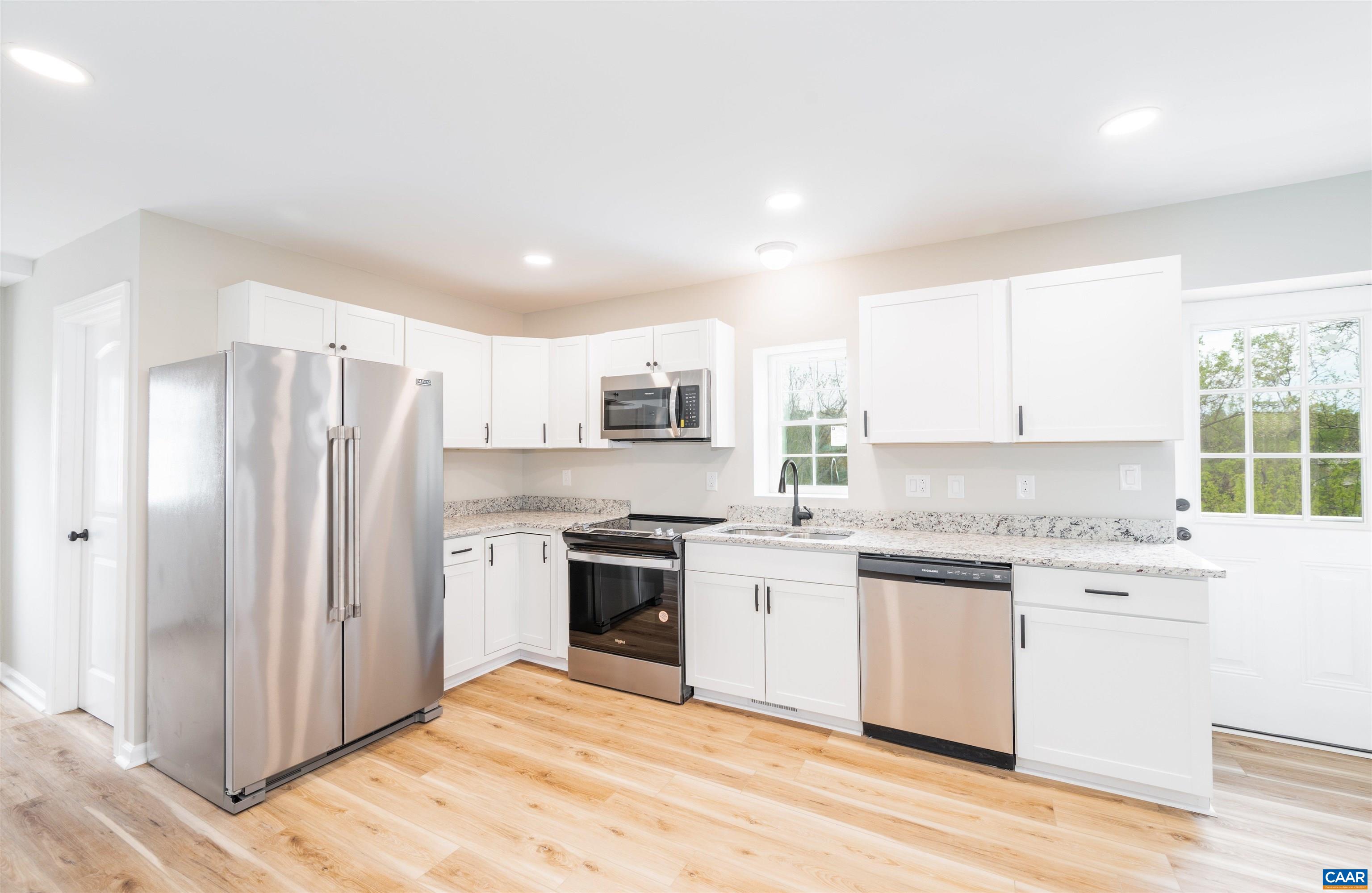 839 Ridge Street Charlottesville, VA 22902 - Photo 11 of 26 a kitchen with stainless steel appliances granite countertop a stove top oven a refrigerator a sink and dishwasher with white cabinets