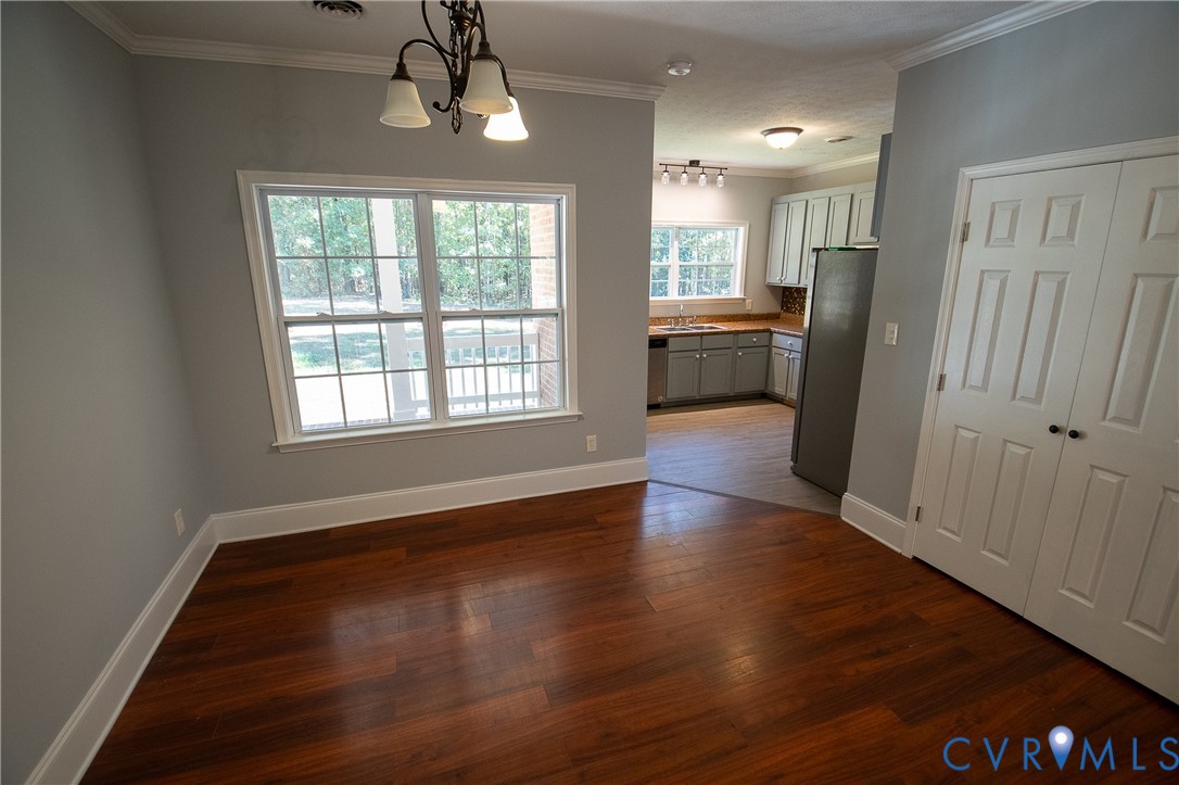 7491 Richmond Road Amelia Court House, VA 23002 - Photo 11 of 39 a view of a kitchen with a refrigerator a ceiling fan and wooden floor
