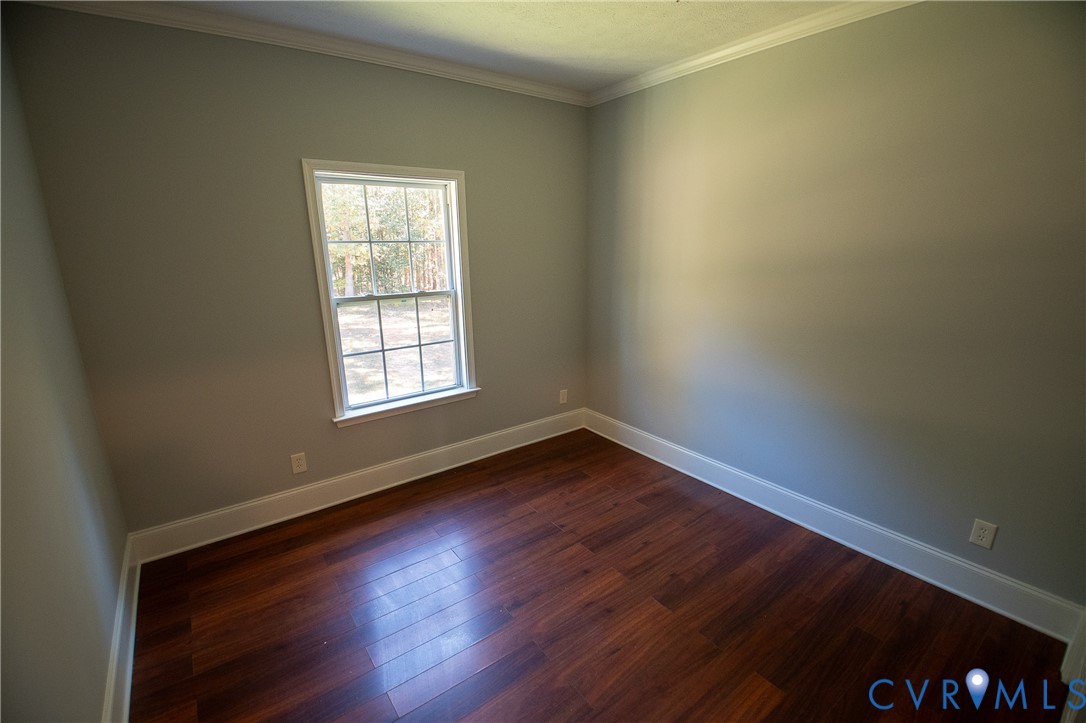 7491 Richmond Road Amelia Court House, VA 23002 - Photo 13 of 39 a view of an empty room with wooden floor and a window