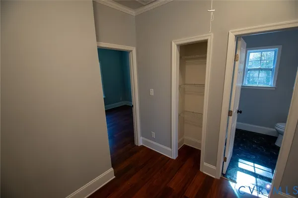 a bathroom with a sink a toilet a window and vanity