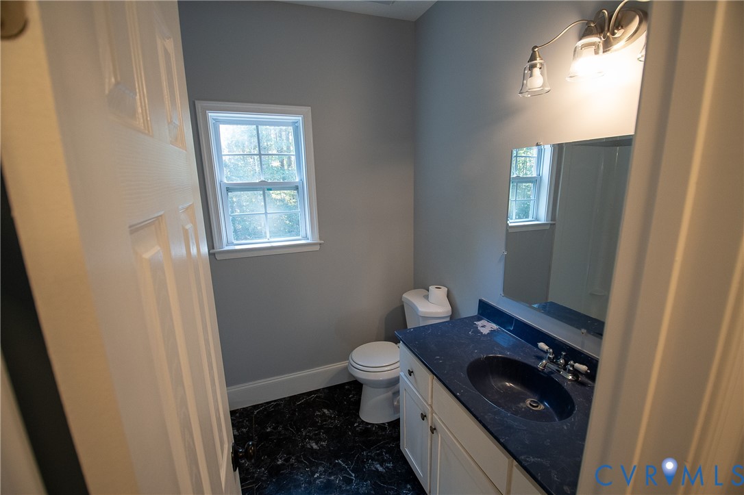 7491 Richmond Road Amelia Court House, VA 23002 - Photo 17 of 39 a bathroom with a sink a toilet a window and vanity