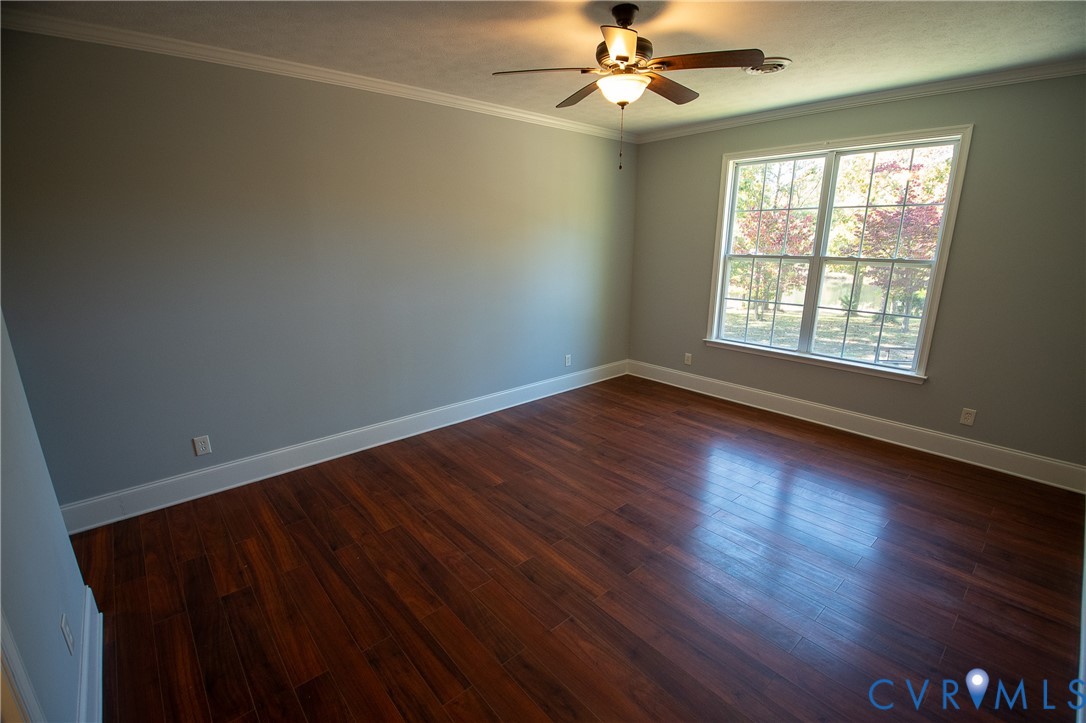 7491 Richmond Road Amelia Court House, VA 23002 - Photo 24 of 39 an empty room with wooden floor fan and windows