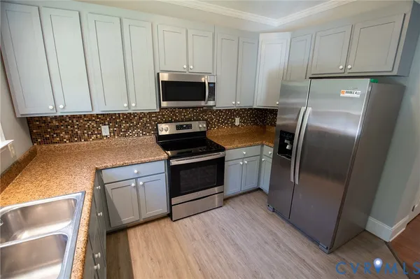 a kitchen with white cabinets and stainless steel appliances