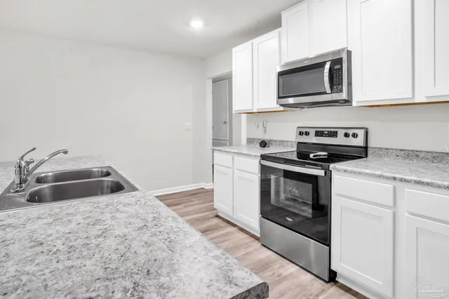 a kitchen with granite countertop a sink and steel stove