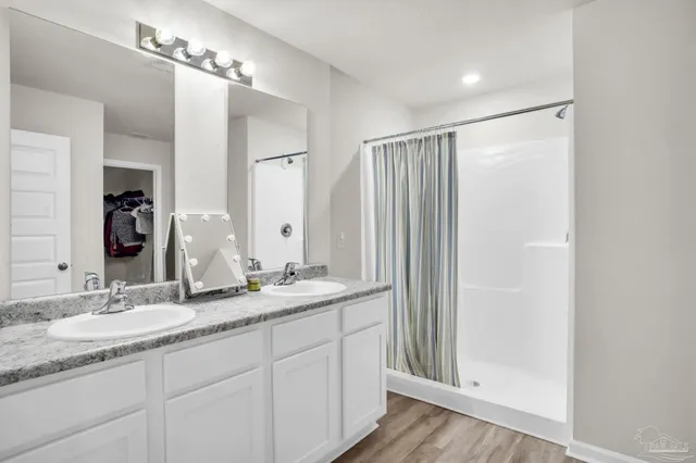 a bathroom with double vanity and a mirror