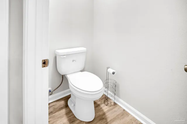 a white toilet sitting next to a white wall