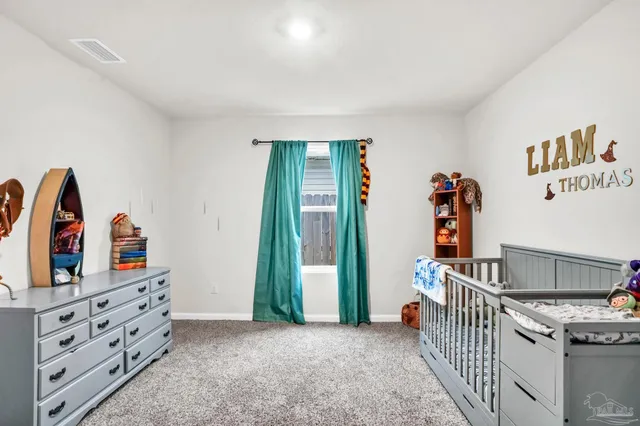 a view of an empty room with furniture and window