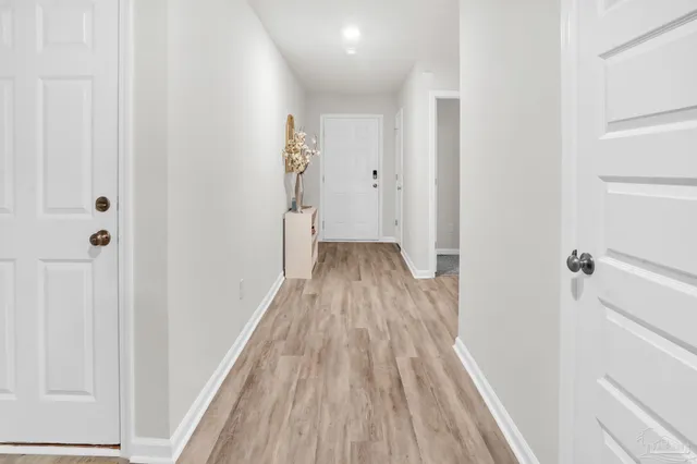 a view of a hallway with wooden floor and staircase