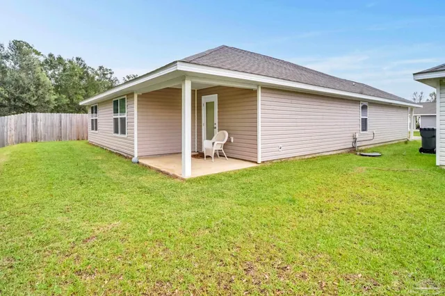 a view of a house with a yard and sitting area