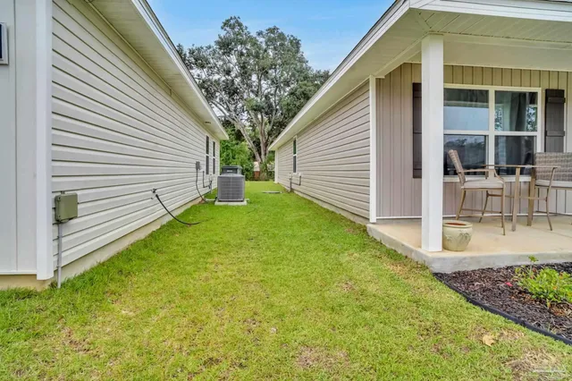 a view of a backyard with plants and large tree