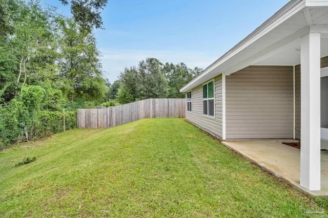 a view of a backyard with a cabin and wooden fence