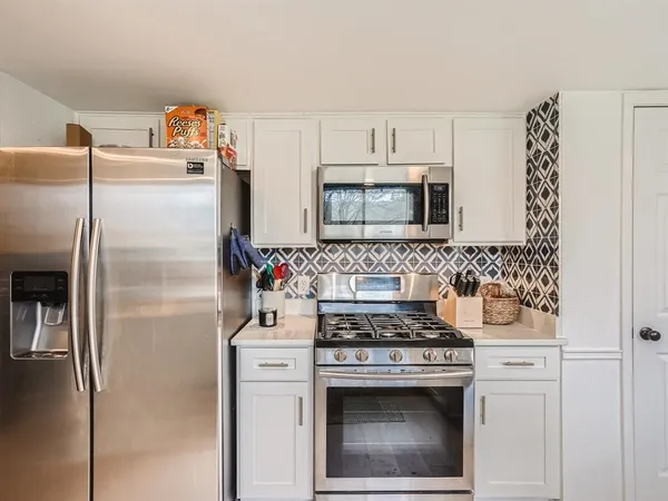a kitchen with refrigerator a microwave a stove and cabinets