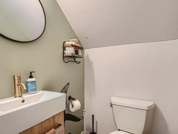 a bathroom with a sink a toilet and mirror