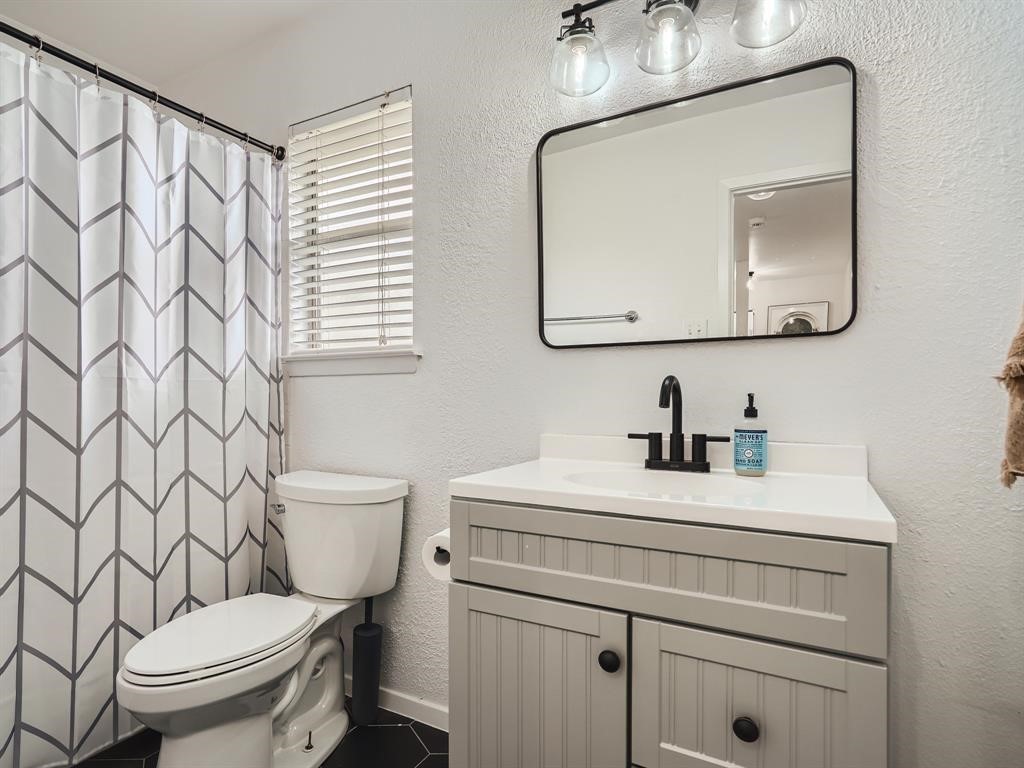 7701 Copano Drive Austin, TX 78749 - Photo 22 of 27 a bathroom with a toilet sink vanity and mirror