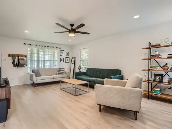 a living room with furniture and a wooden floor