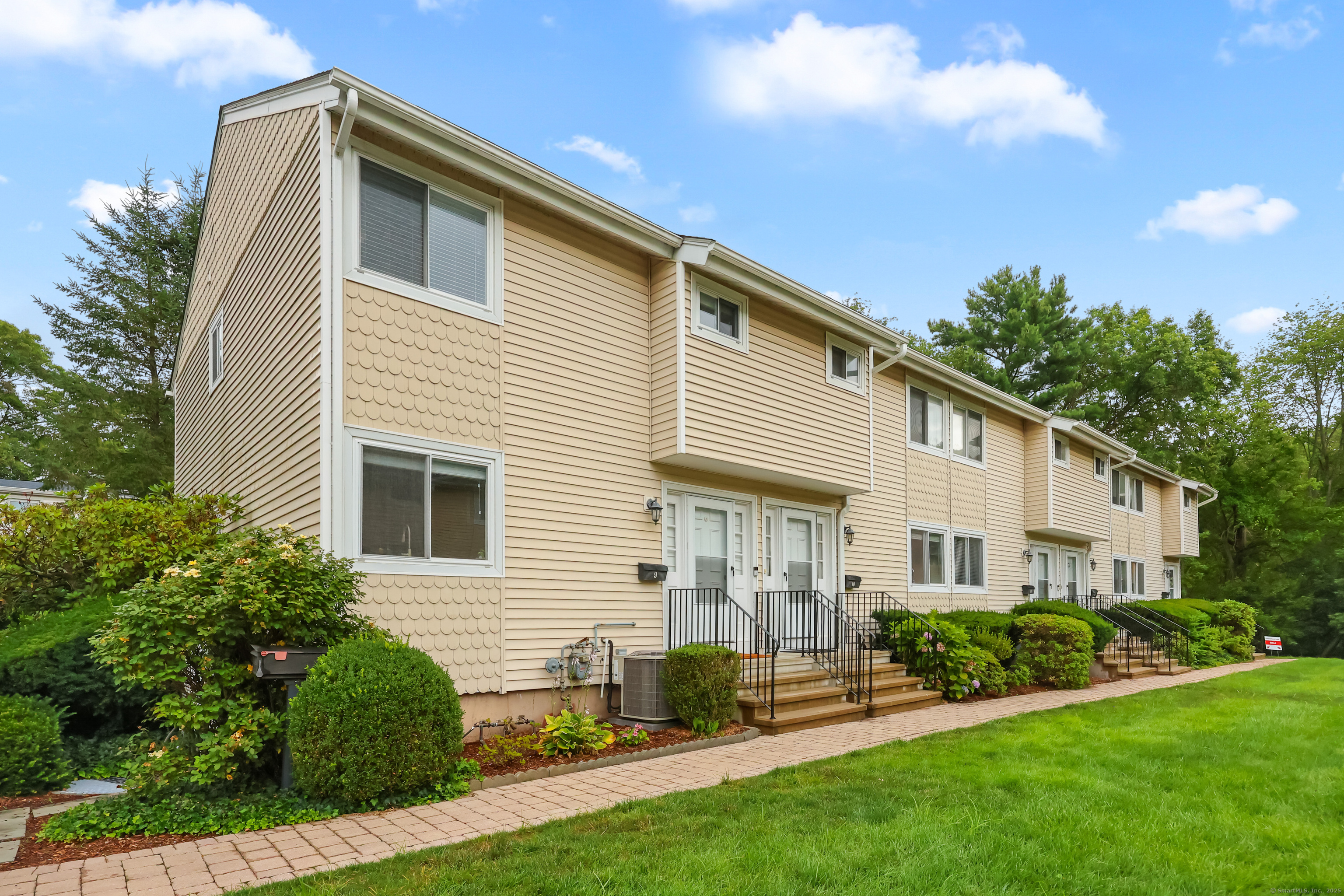 75 Cos Cob Avenue, Unit 10 Greenwich, CT 06807 - Photo 1 of 1 a front view of a house with a yard and porch