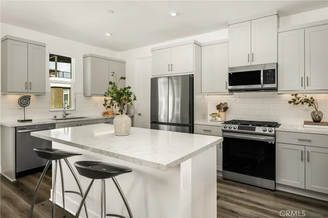 a living room with kitchen island furniture and a view of kitchen