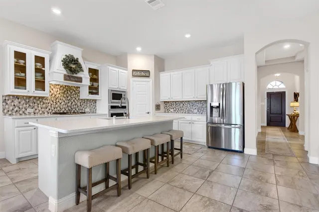 a kitchen with white cabinets and white appliances