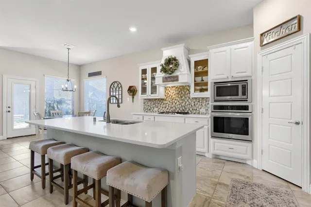 a kitchen with a sink and chairs