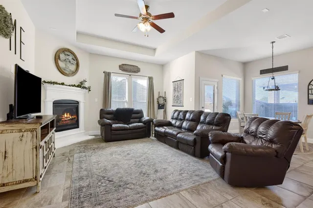 a living room with furniture a flat screen tv and a fireplace