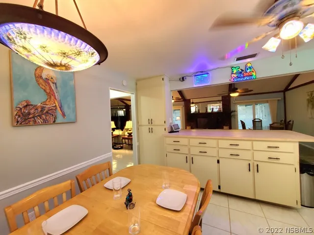 a kitchen with a stove a faucet a dining table and chairs with wooden floor