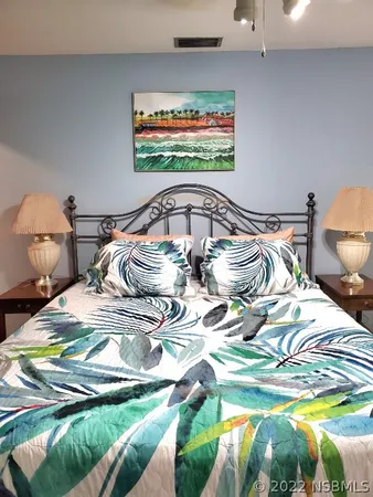 a bedroom with a bed and painting on the wall