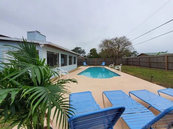 a view of house with swimming pool outdoor seating