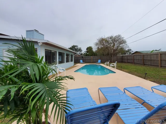 a view of house with swimming pool outdoor seating