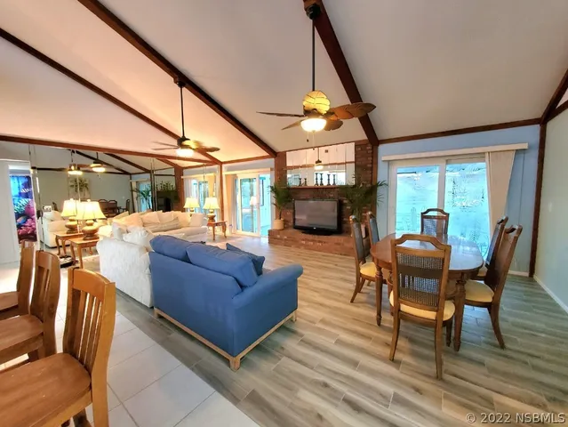 a living room with furniture a fireplace and a floor to ceiling window