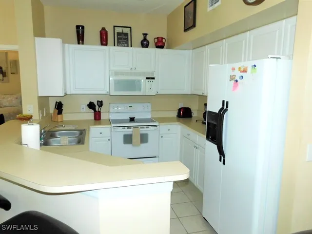a kitchen with a sink a refrigerator and cabinets