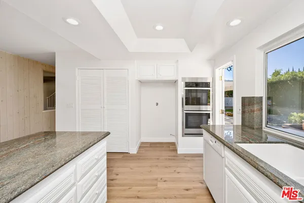 a large kitchen with kitchen island a sink stainless steel appliances and cabinets