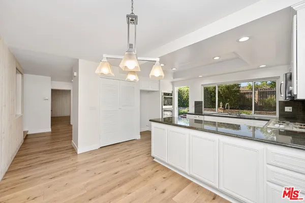 a view of a kitchen with stainless steel appliances granite countertop a sink and dishwasher with wooden floor
