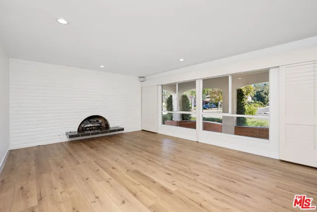 a view of a livingroom with wooden floor and glass windows