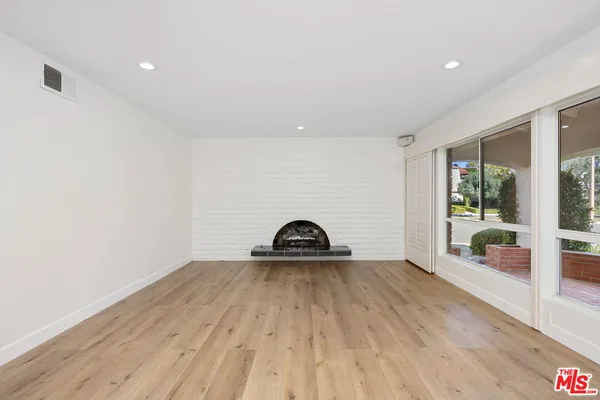a view of a room with wooden floor and window