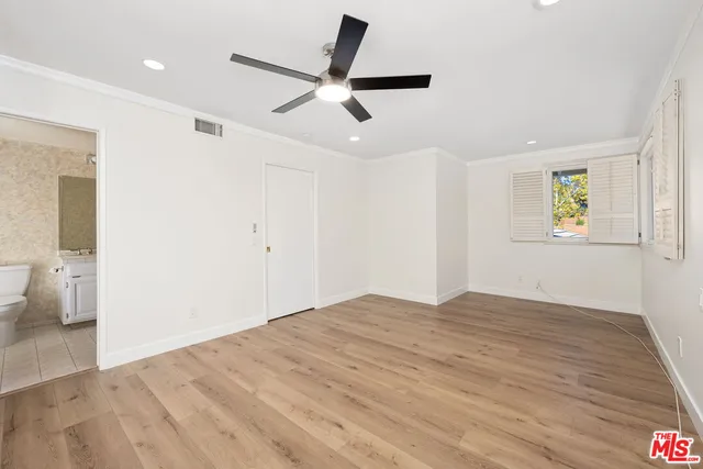 a view of empty room with wooden floor and window