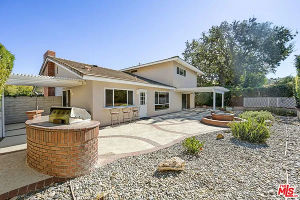 a front view of a house with a yard and sitting area